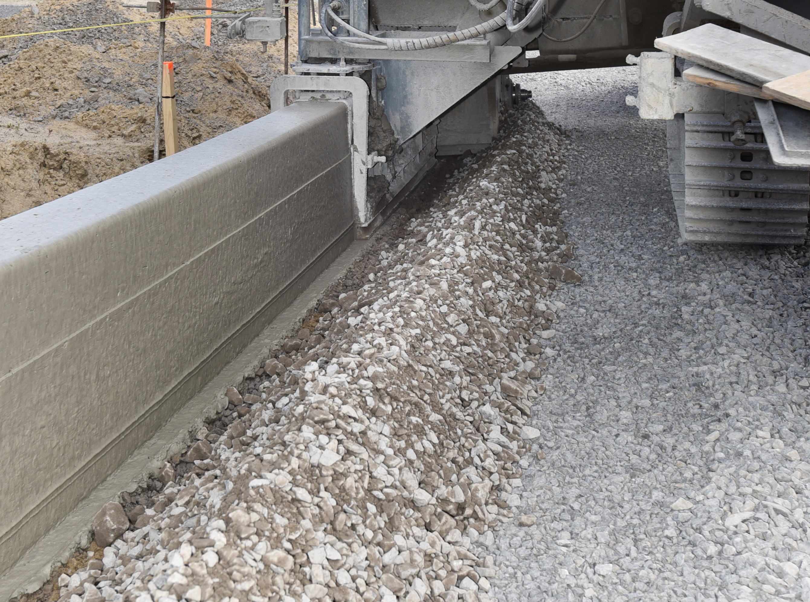 Machine extruding concrete on construction site with concrete fibers